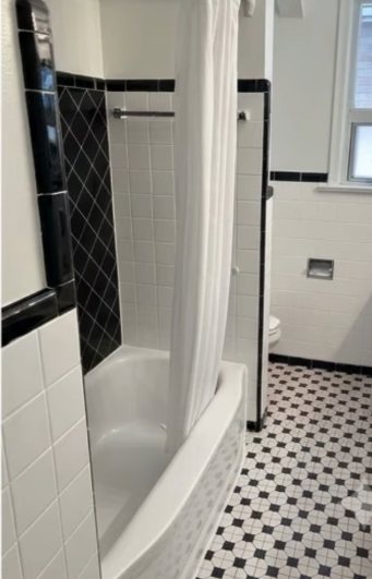 Bathroom finished in black and white tile with a diamond accent and checkered floor