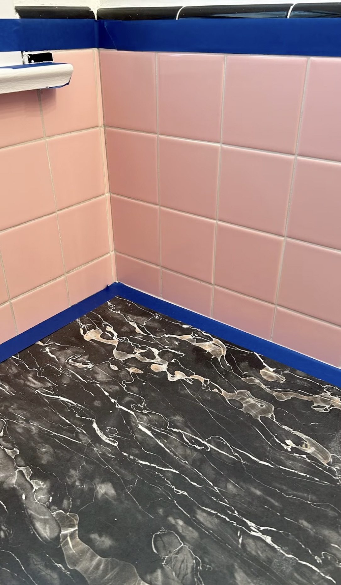 Bathroom tile masked off with painter’s tape ahead of a refinish