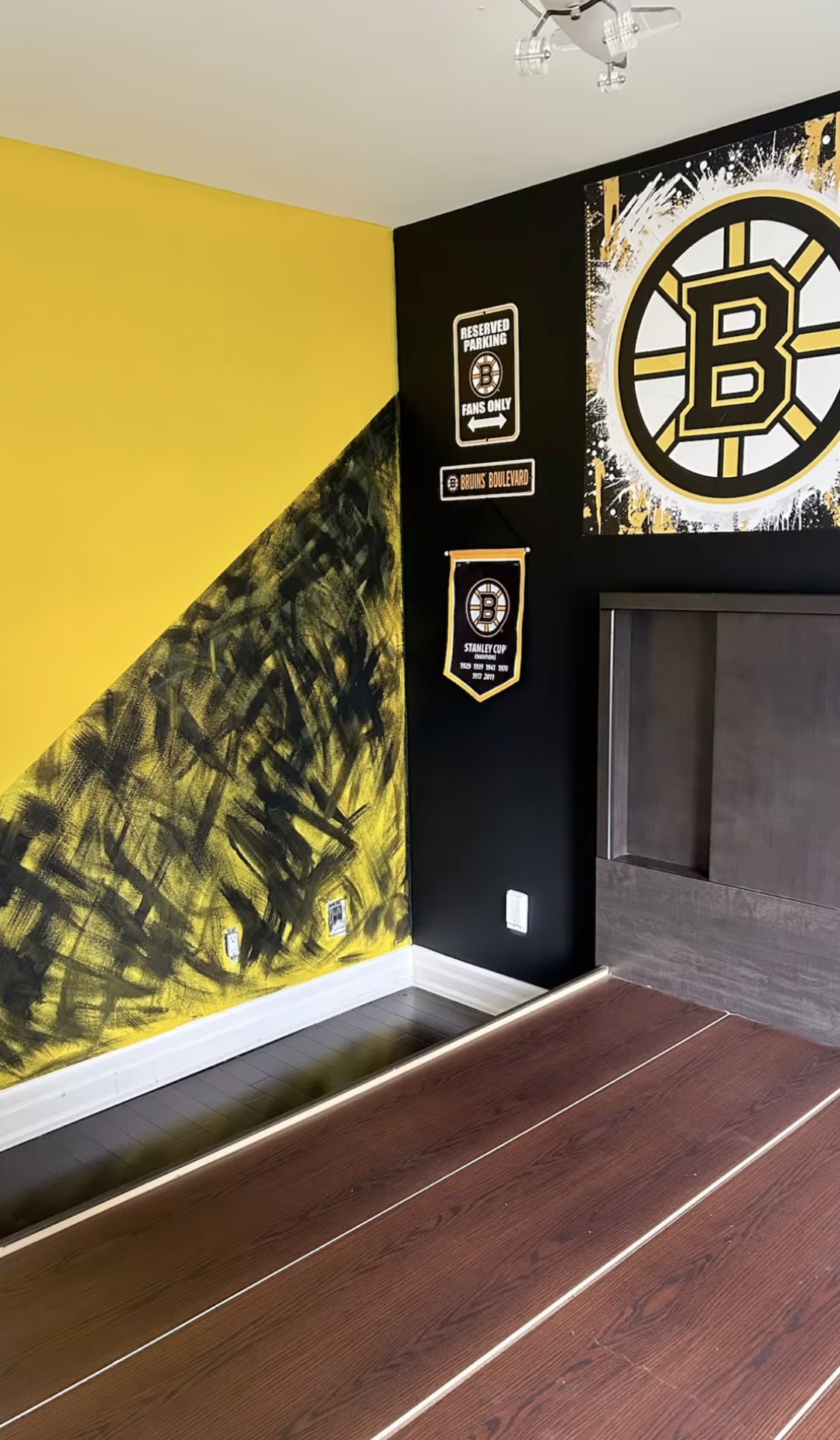 Living room feature wall in black and yellow with a hand-brushed diagonal, beside a fireplace