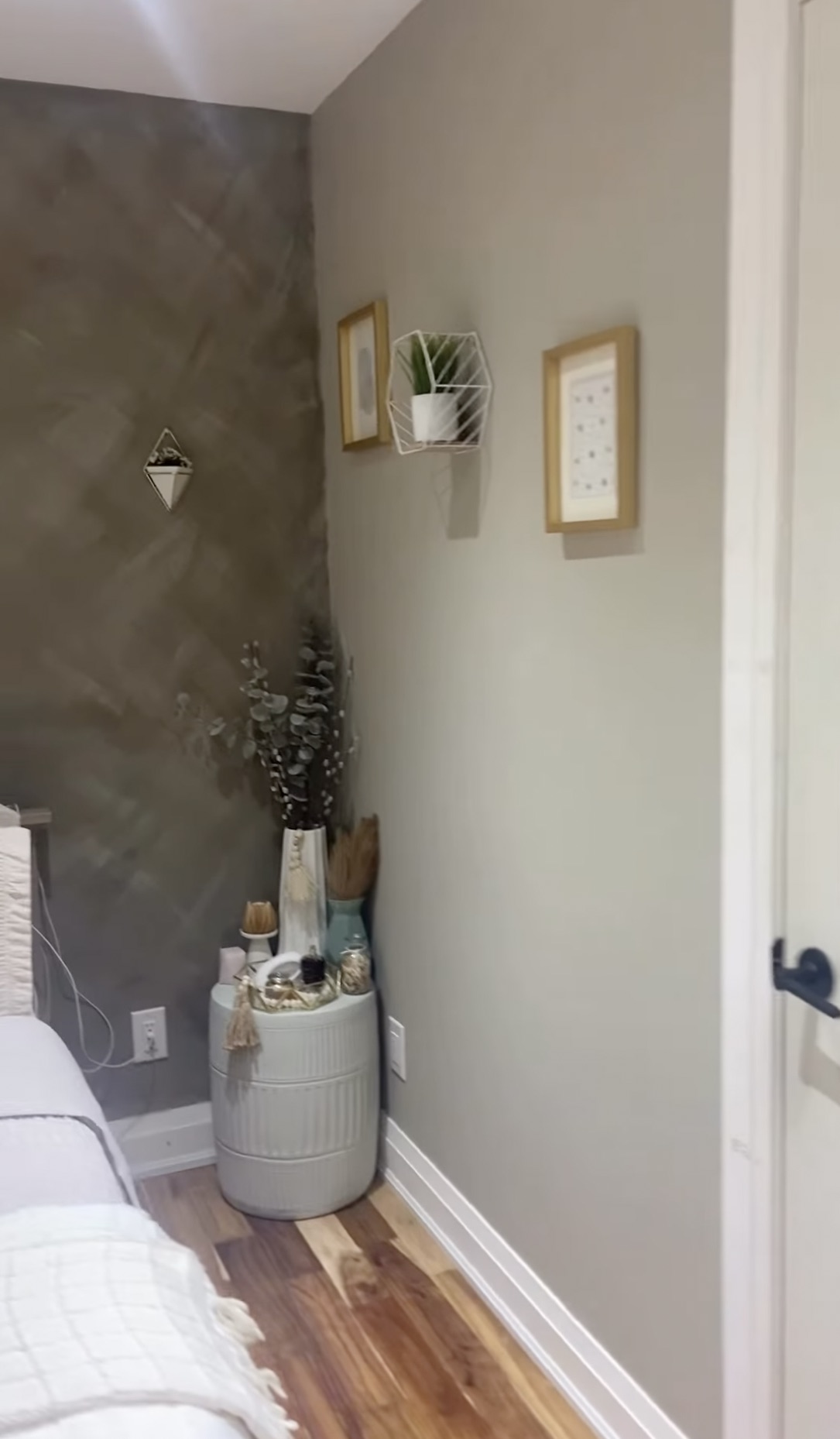 Bedroom with a soft grey accent wall, white trim, and neutral styling